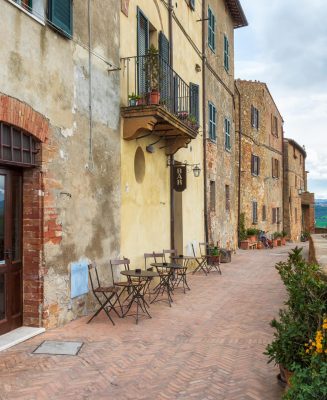 A narrow picturesque medieval street along the city wall and view to the valley in old town of Pienza in Tuscany, Italy